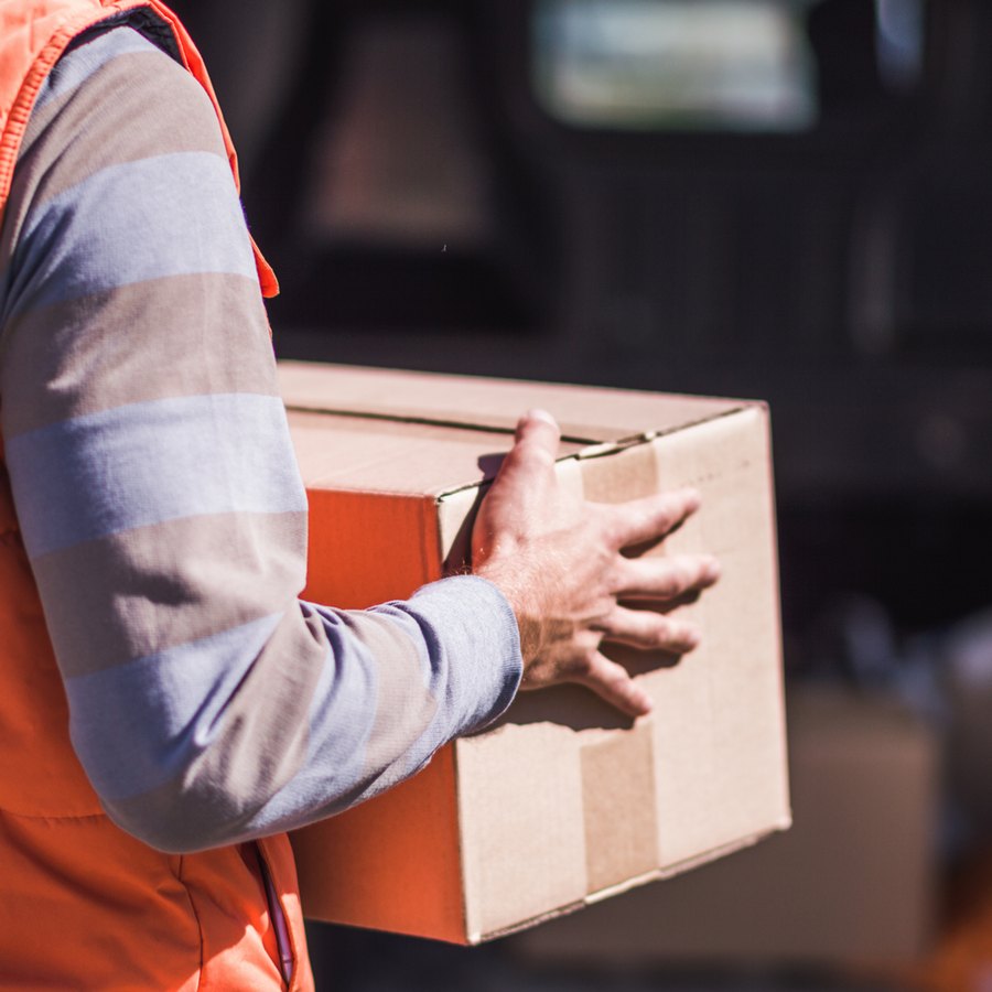 Mitarbeiter der HSG trägt ein Paket zur Verladung